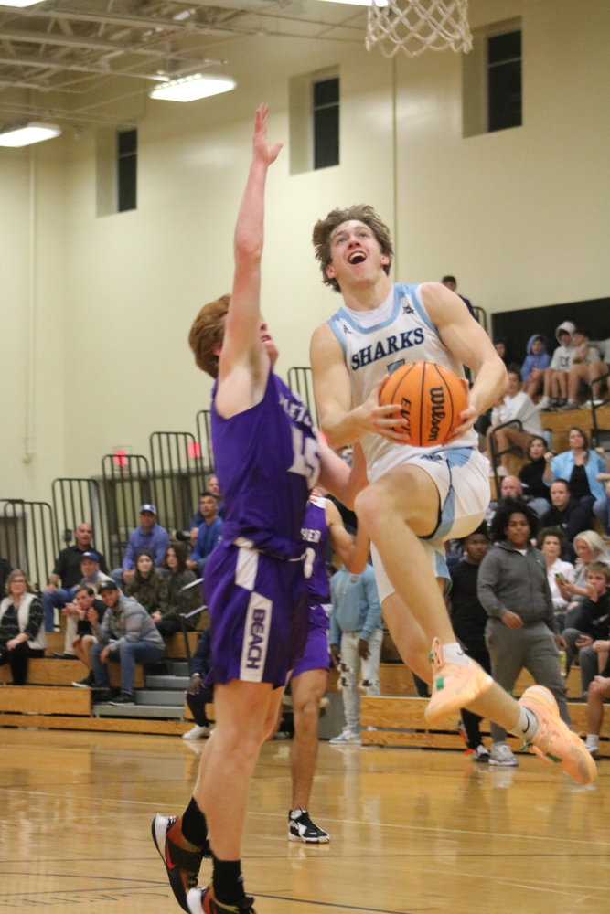 Luke Pirris flies through the air on his way to the basket against Fletcher in the district championship Feb. 11.